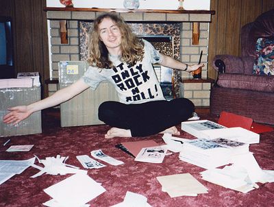 Darren with piles of fanzines and flyers (1995)